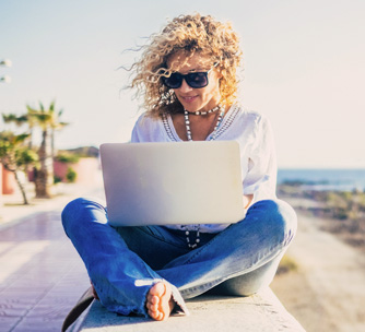 kobieta pracująca na plaży bo ma wirtualne biuro